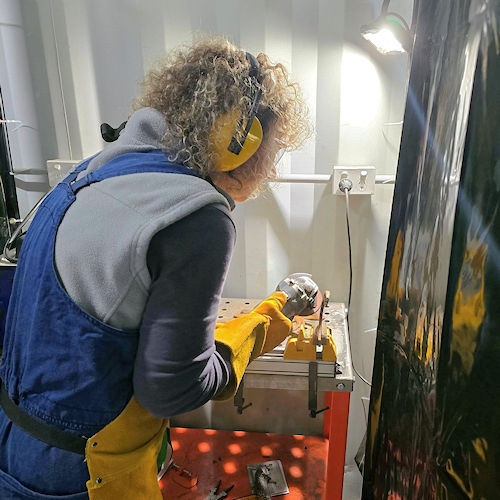 Woman welding with supervision